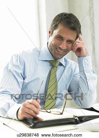 Business man on his desk View Large Photo Image Stock Photo - Business man on his desk. Fotosearch