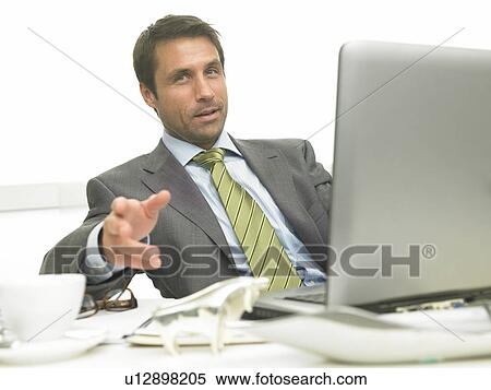 Stock Photography - Business man on his desk with a laptop. Fotosearch