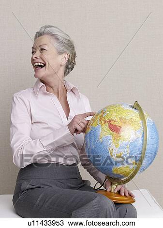 Senior adult with a globe View Large Photo Image Stock Image - Senior adult with a globe. Fotosearch