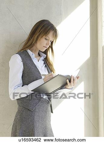 Stock Image - Woman writng in a datebook. Fotosearch