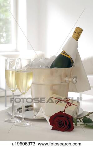 Champagne bottle in an ice bucket, glasses and gift View Large Photo Image Stock Image - Champagne bottle in an ice bucket, glasses and gift. Fotosearch