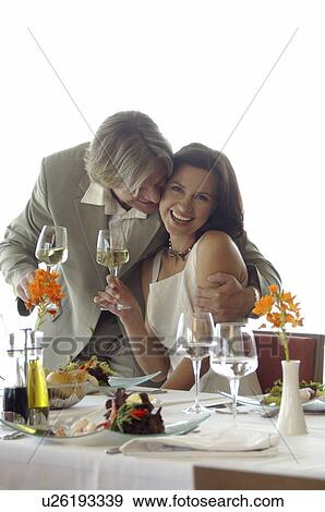 Couple at a set table with wine glasses View Large Photo Image Stock Photo - Couple at a set table with wine glasses. Fotosearch