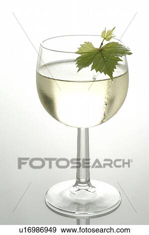 Stock Photo - Glass of white wine with a vine leaf. Fotosearch