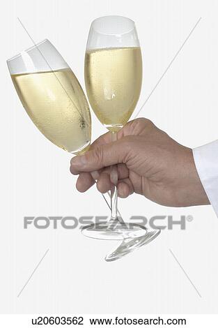 Stock Image - Holding two champagne glasses. Fotosearch