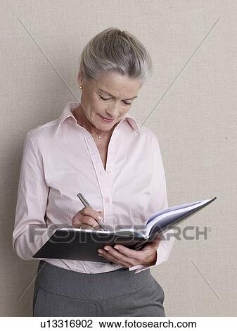 Senior adult in business clothing holding datebook View Large Photo Image Stock Image - Senior adult in business clothing holding datebook. Fotosearch
