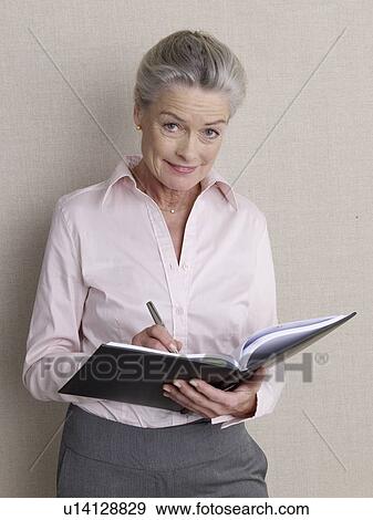 Senior adult in business clothing holding air ticket View Large Photo Image Stock Photo - Senior adult in business clothing holding air ticket. Fotosearch