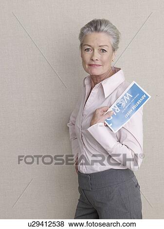 Senior adult in business clothing holding air ticket View Large Photo Image Stock Photo - Senior adult in business clothing holding air ticket. Fotosearch