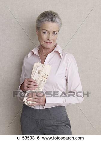 Senior adult in business clothing holding newspaper View Large Photo Image Stock Photograph - Senior adult in business clothing holding newspaper. Fotosearch