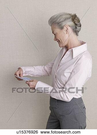Senior adult in business clothing holding air ticket View Large Photo Image Stock Photograph - Senior adult in business clothing holding air ticket. Fotosearch