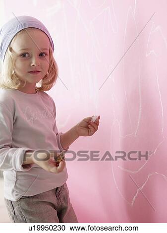 Stock Image - Blond girl wearing a headscarf is painting. Fotosearch