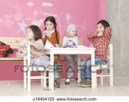 Four children sitting at the table View Large Photo Image Stock Image - Four children sitting at the table. Fotosearch