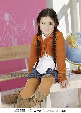 Girl sitting on the table next to globe View Large Photo Image Stock Image - Girl sitting on the table next to globe. Fotosearch