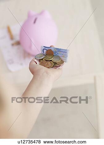 Hand full of money and a piggy bank View Large Photo Image Stock Photo - Hand full of money and a piggy bank. Fotosearch