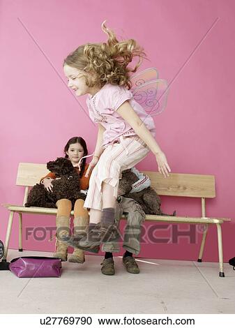 Stock Image - Jumping girl wearing wings. Fotosearch