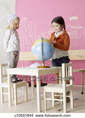Picture - Two girls with a globe. Fotosearch