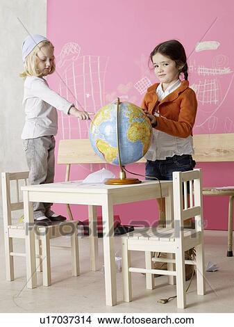 Picture - Two girls with a globe. Fotosearch