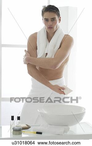 Man standing in front of a washbowl with body lotion View Large Photo Image Picture - Man standing in front of a washbowl with body lotion. Fotosearch