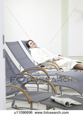 Stock Photograph - Man wearing a bath robe on a deckchair. Fotosearch
