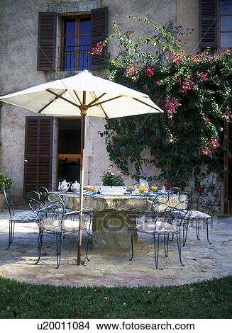 Picture - Breakfast table on the terrace with parasol. Fotosearch