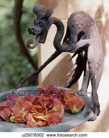 Stock Image - Garden sculpture and bougainvillea blossoms. Fotosearch