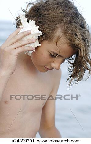 Boy at the sea with a mussel View Large Photo Image Stock Image - Boy at the sea with a mussel. Fotosearch