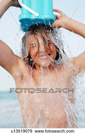 Stock Photo - Boy sousing himself with water. Fotosearch