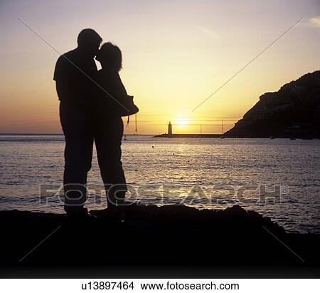Picture - Couple at Sunset at the sea. Fotosearch