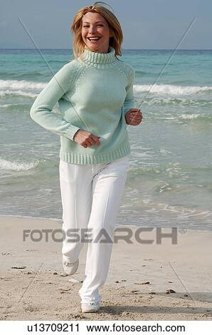 Jogging woman in turquoise sweater at the sea View Large Photo Image Stock Image - Jogging woman in turquoise sweater at the sea. Fotosearch