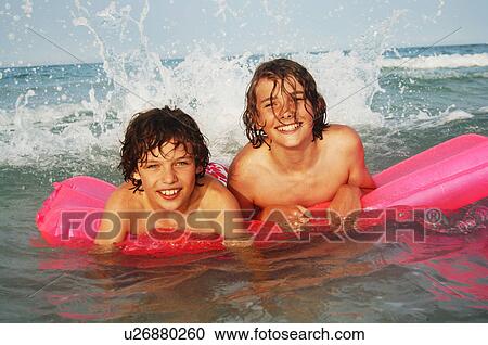 Stock Image - Two boys with an air mattress. Fotosearch
