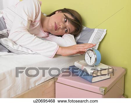 Stock Photo - Woman hitting the alarmclock. Fotosearch
