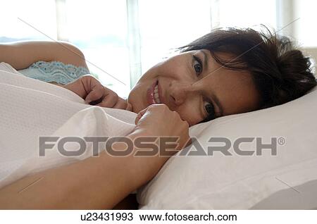 Stock Image - woman lying in her bed. Fotosearch