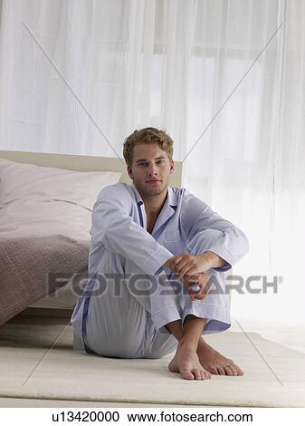 Stock Image - young man in blue pyjamas. Fotosearch