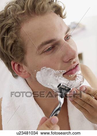 Picture - young man shaving. Fotosearch