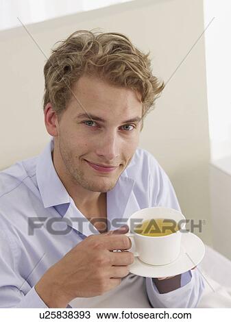 Stock Image - young man with a cup of tea. Fotosearch