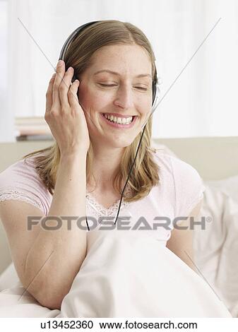 Stock Image - young woman listening music. Fotosearch