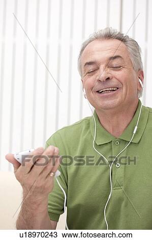 Domestic Life, a senior man listening music with eyes closed and smiling View Large Photo Image Stock Image - Domestic Life, a senior man listening music with eyes closed and smiling. Fotosearch