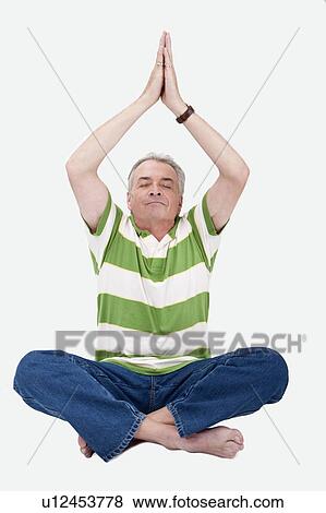 Stock Photo - Domestic Life, a senior man making lotus position with eyes closed. Fotosearch