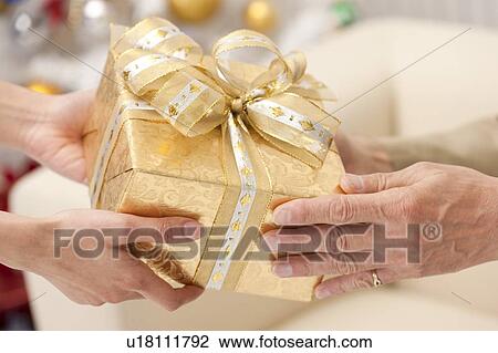 Stock Image - Domestic Life, Close-up of hands holding gift together. Fotosearch