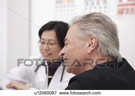 Senior-aged man taking medical exam and smiling with the doctor View Large Photo Image Stock Photo - Senior-aged man taking medical exam and smiling with the doctor. Fotosearch