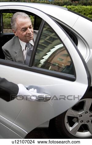 Picture - Senior businessman getting down the car. Fotosearch