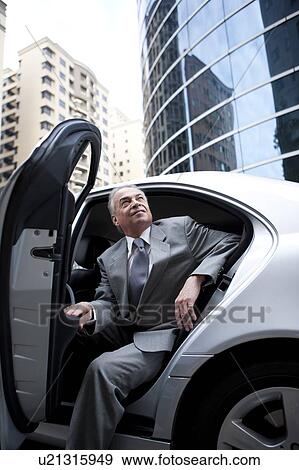 Senior businessman getting off the car View Large Photo Image Stock Photo - Senior businessman getting off the car. Fotosearch