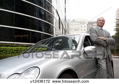 Senior businessman standing beside the car and looking up with smile View Large Photo Image Stock Image - Senior businessman standing beside the car and looking up with smile. Fotosearch