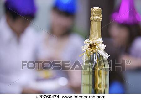 Picture - Close-up of a bottle of champagne with bow. Fotosearch