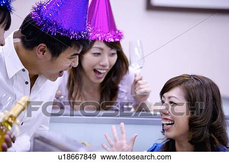Stock Photo - Colleagues celebrating and laughing happily together. Fotosearch