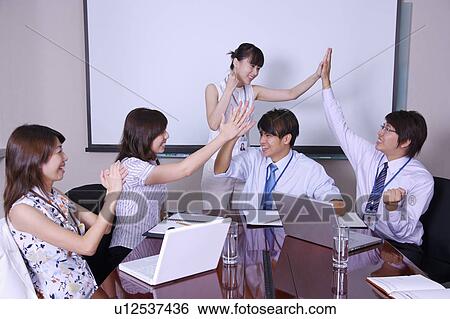 Colleagues making high-five together to celebrate success View Large Photo Image Stock Photograph - Colleagues making high-five together to celebrate success. Fotosearch
