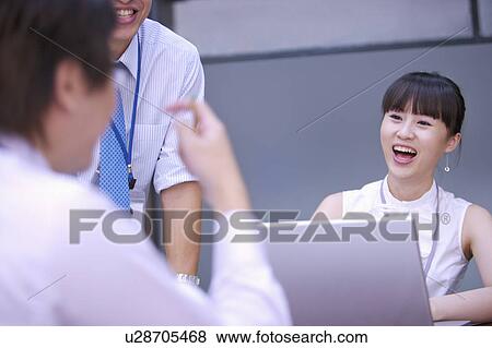 Stock Photo - Colleagues smiling happily together. Fotosearch