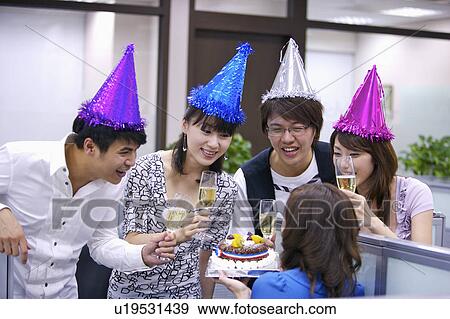Colleagues wearing party hats and holding drink to celebrate View Large Photo Image Stock Photo - Colleagues wearing party hats and holding drink to celebrate. Fotosearch