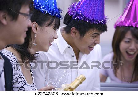 Four colleagues wearing headwear and laughing happily together View Large Photo Image Stock Photograph - Four colleagues wearing headwear and laughing happily together. Fotosearch