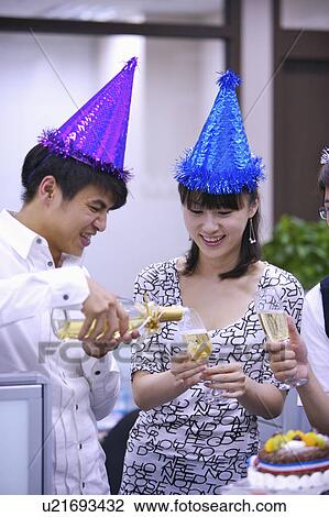 Young man pouring champagne into young woman's glass for celebrating View Large Photo Image Stock Image - Young man pouring champagne into young woman's glass for celebrating. Fotosearch