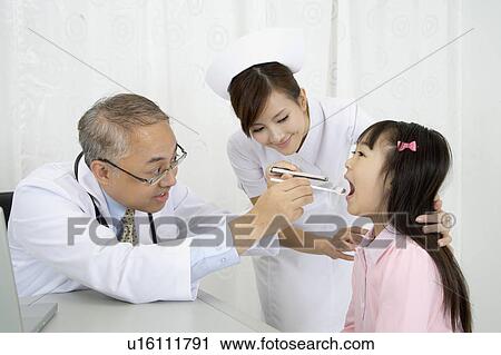 Doctor and nurse checking little girl's mouth View Large Photo Image Stock Image - Doctor and nurse checking little girl's mouth. Fotosearch